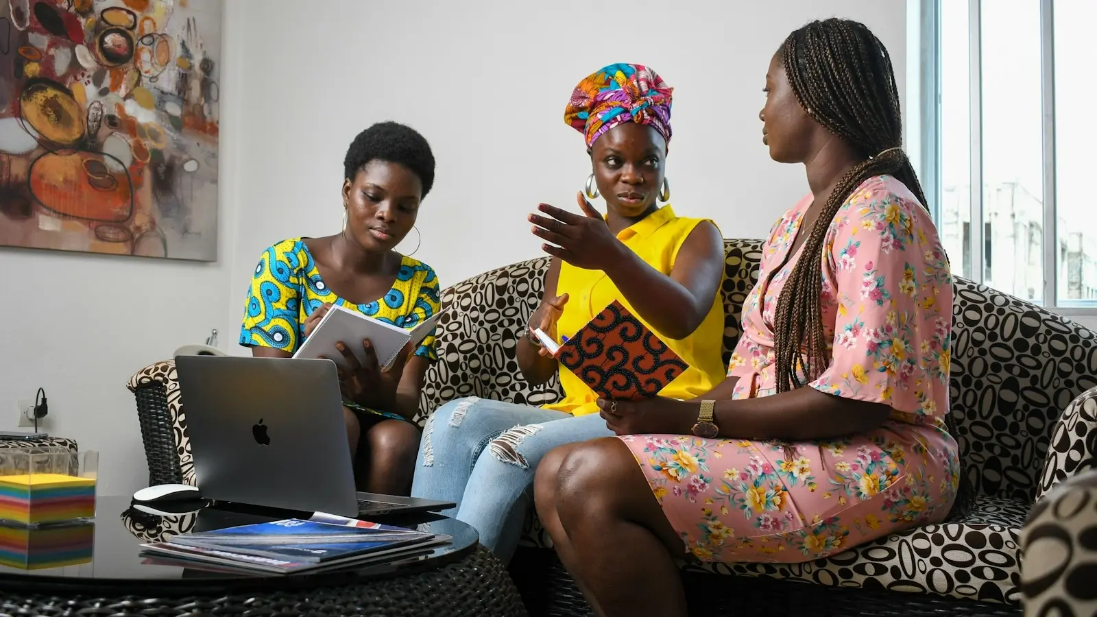 a group of people sitting on a couch looking at a laptop