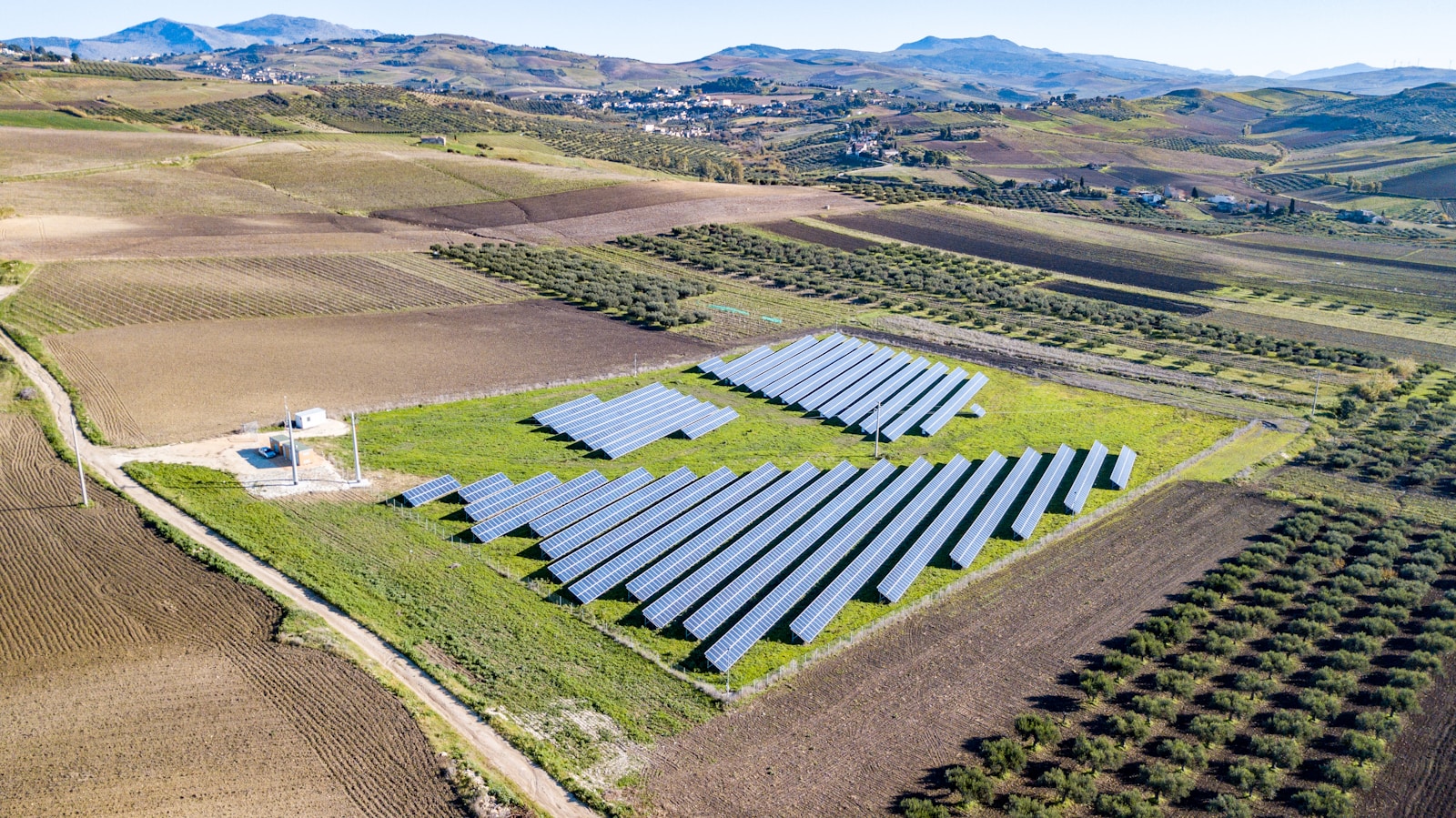 aerial view of green grass field with photovoltaic during daytime