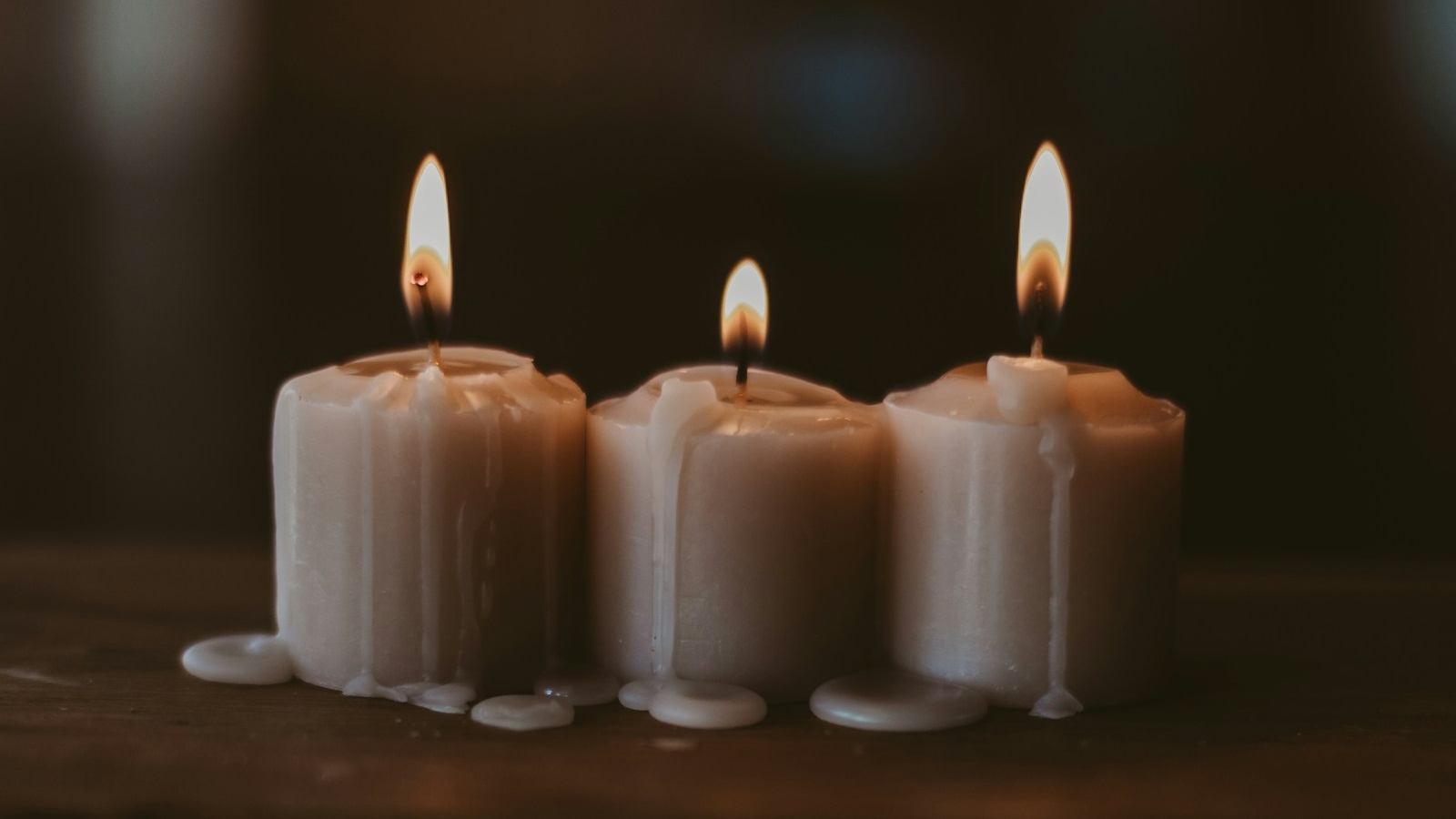 white candles on black surface