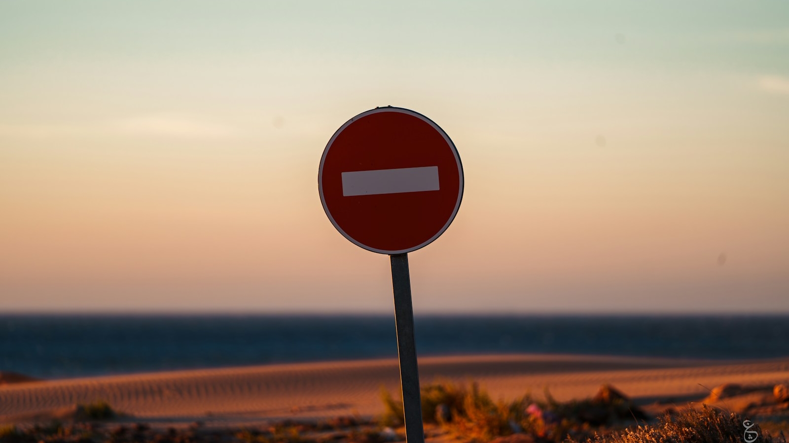 a red street sign sitting on the side of a road