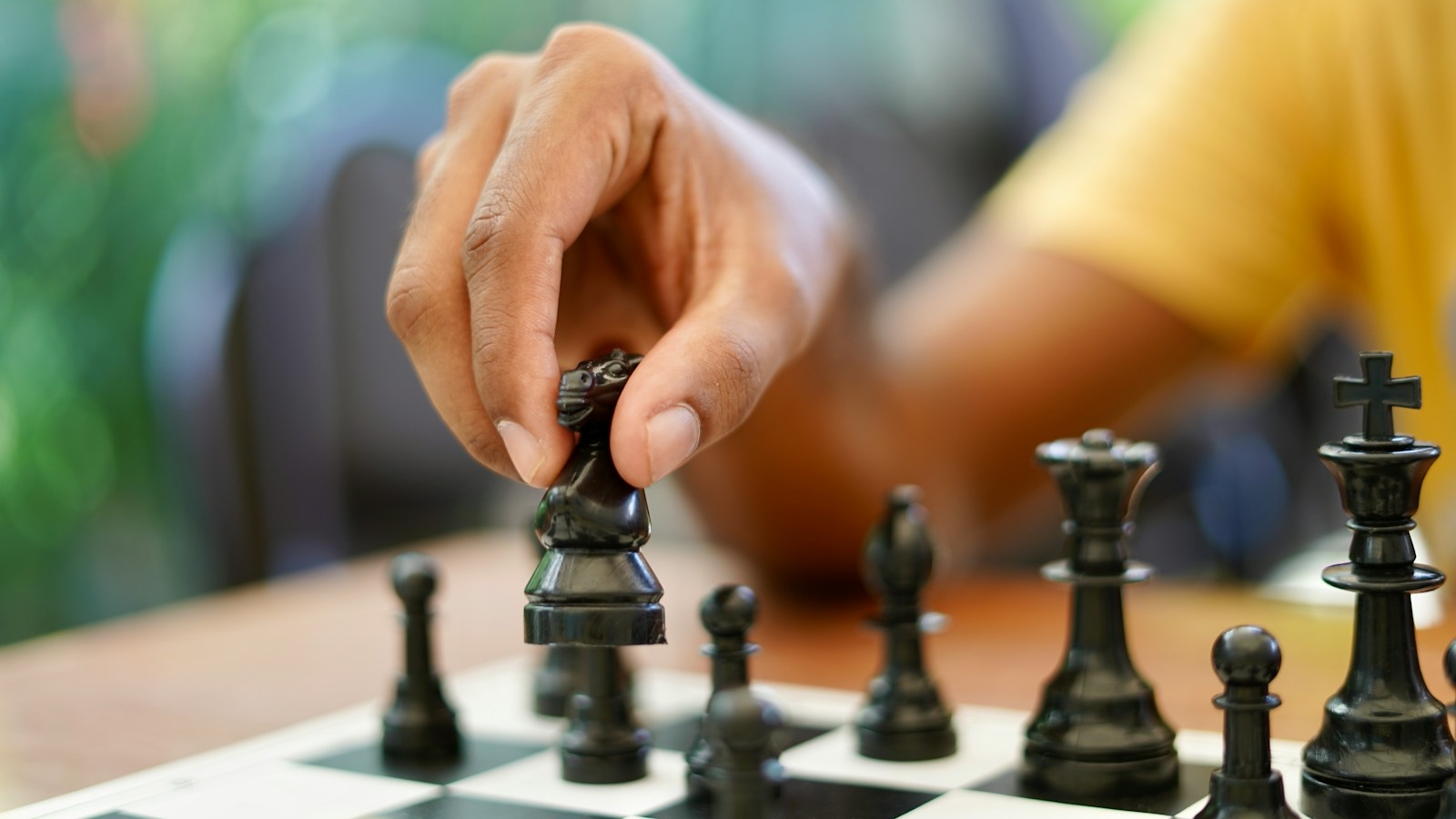 person holding black and silver chess piece
