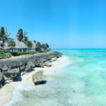 rocky beach with white cottages under clear blue sky